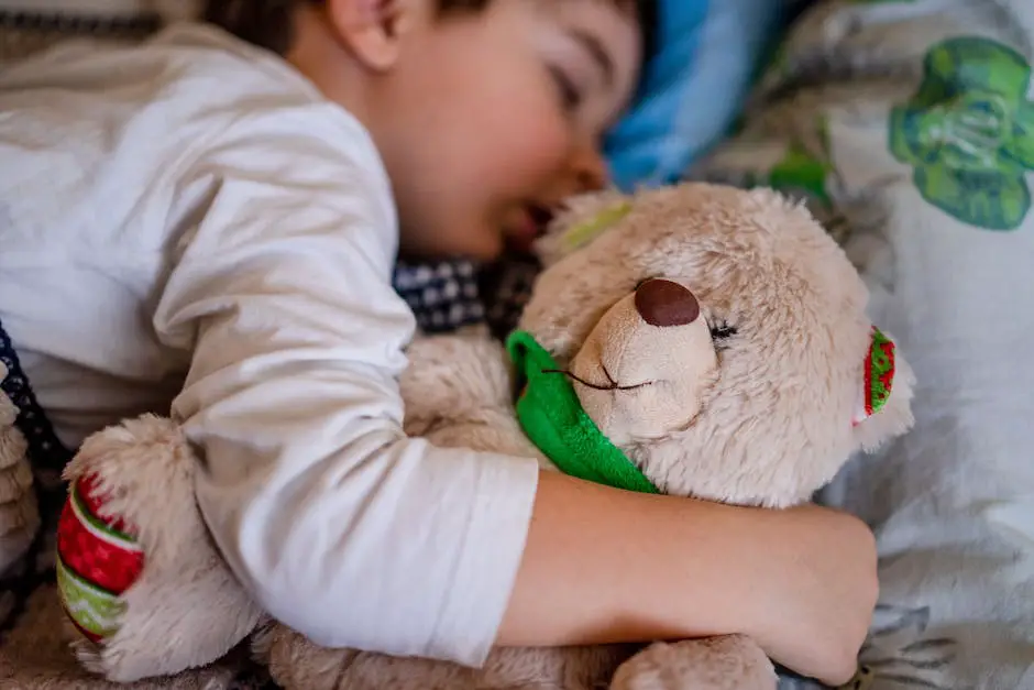 A child sleeping in their bed with a soft teddy bear next to them.