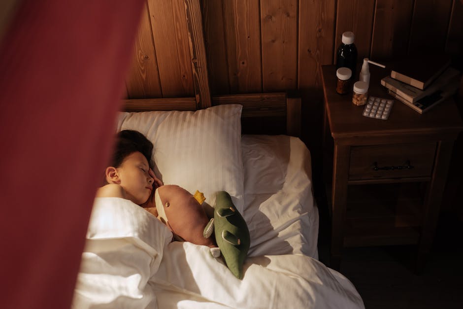 An image of a person lying in bed with a box of tissues and a pill bottle next to them, signifying the impact of illness and medication side effects on missing college classes.