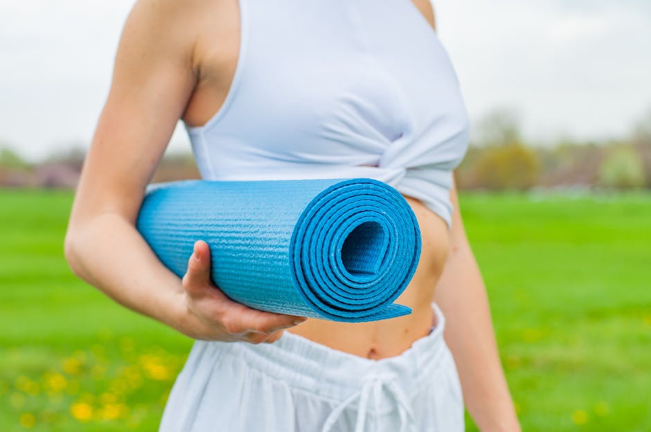 A person exercising outside with a water bottle and yoga mat that illustrate the importance of regular exercise for better sleep quality.