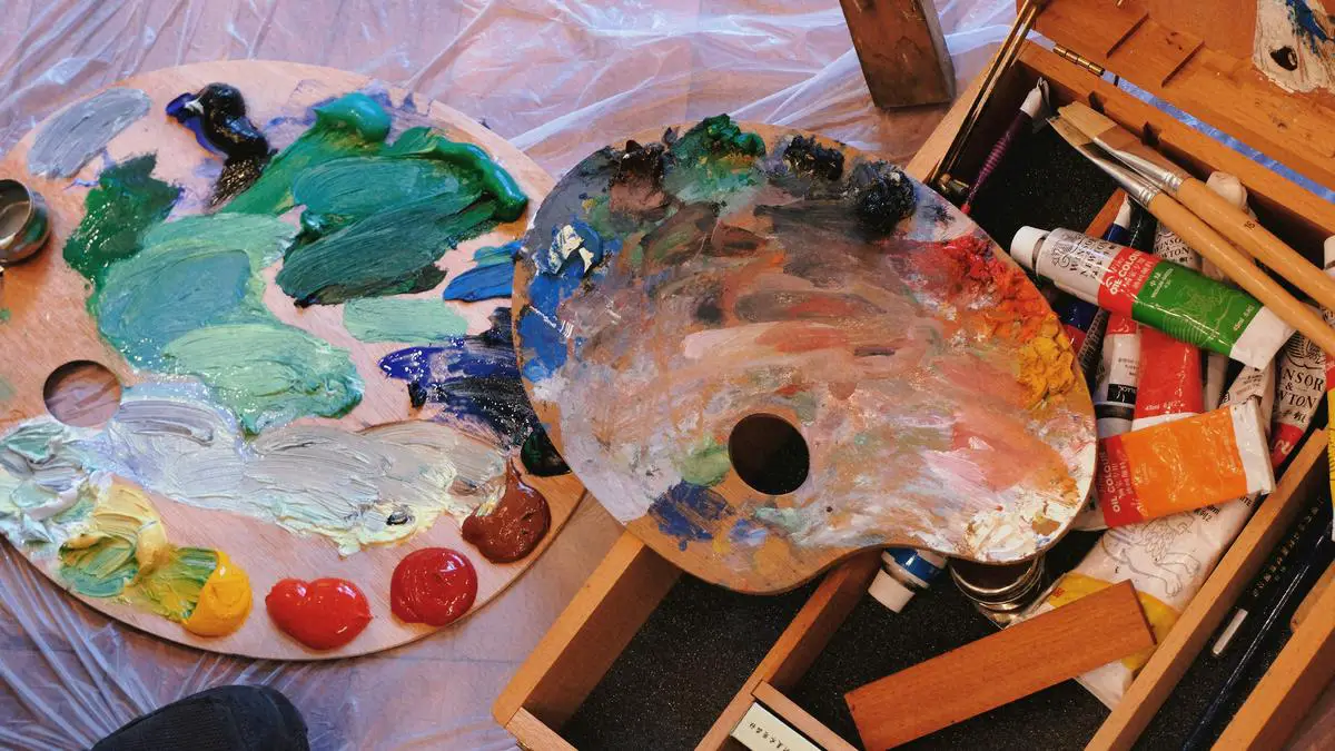 An image showing a paintbrush and a palette with colorful paints.