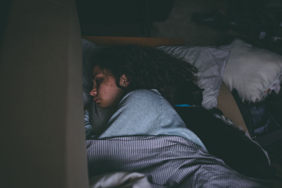 A person sleeping in bed during a power outage with no lights on in the room.