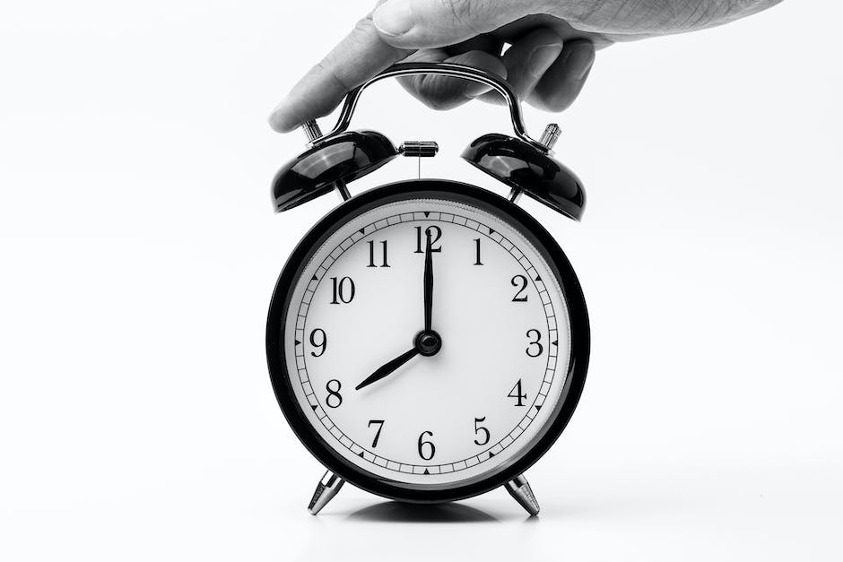 Image depicting a person's hands holding a clock, symbolizing time management for better punctuality and organization.